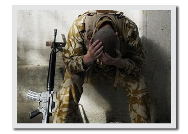 Soldier sitting by his rifle with his head down in dispair.